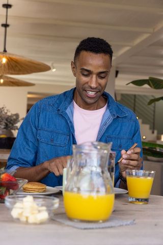 Smiling Man Enjoying Pancakes in Casual Cafe Atmosphere
