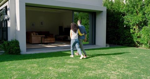 Couple Strolling Towards Modern Home Patio
