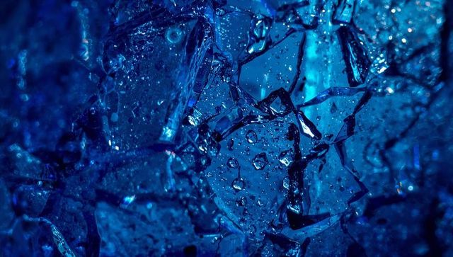 Deep blue crystal shards macro showing droplets and refracted light