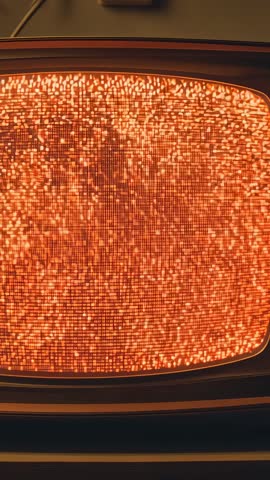 Powering retro CRT TV displaying orange static and glowing bezel in vertical video