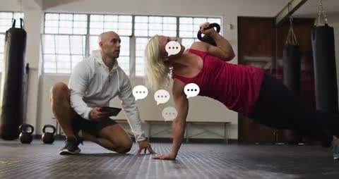 Dedicated Trainer Guides Hardworking Client with Kettlebell Exercise