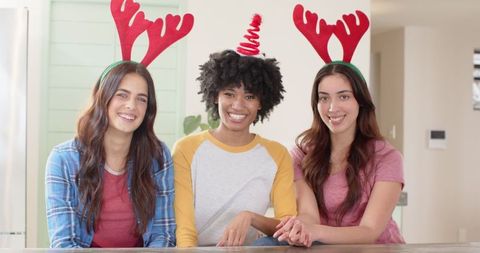 Diverse female friends celebrating holiday with festive headbands