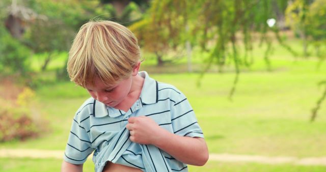 Curious Young Boy Examining Scrape on Stomach in Park - Download Free Stock Images Pikwizard.com