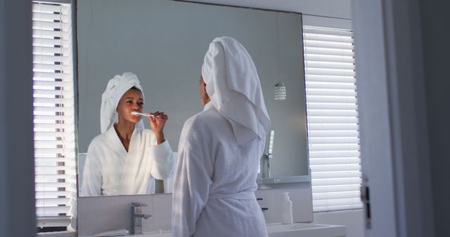 Young Woman Brushing Teeth in Bathroom with Towel Wrapped Hair - Download Free Stock Images Pikwizard.com