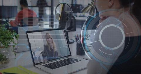 Remote team meeting on laptop with smiling presenter in modern open-plan workspace