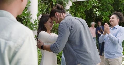 Joyful outdoor wedding ceremony with applauding friends