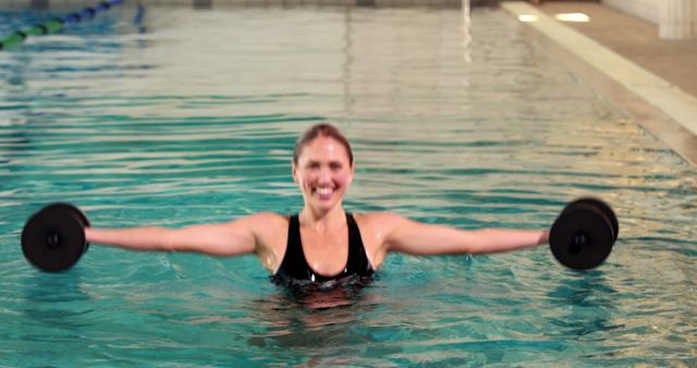 Woman Smiling while Exercising with Dumbbells in Pool - Download Free Stock Images Pikwizard.com