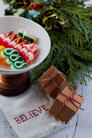 Celebrating holiday cheer with candy canes and rustic gift boxes on evergreen tabletop