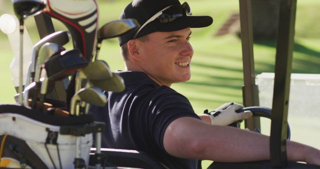 Image of happy caucasian man sitting in cart on golf field. sporty, active lifestyle and playing golf concept.
