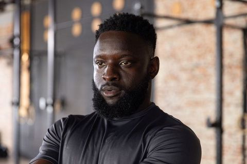 Focused african american athlete standing in industrial gym wearing fitted activewear