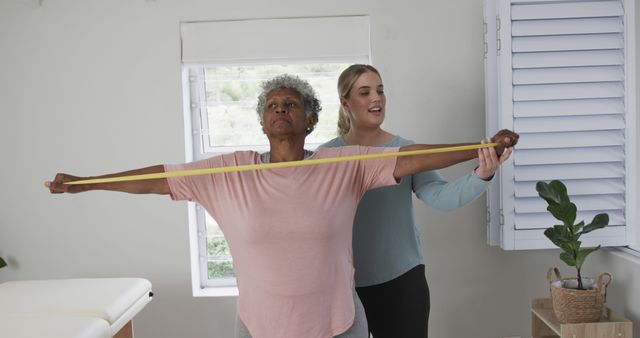 Senior Woman Exercising with Resistance Band Assisted by Personal Trainer - Download Free Stock Images Pikwizard.com