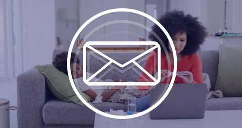 Mother Working with Laptop Beside Son Relaxing with Smartphone