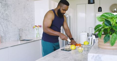 Active Man Preparing Healthy Meal in Modern Kitchen with Marble Accents