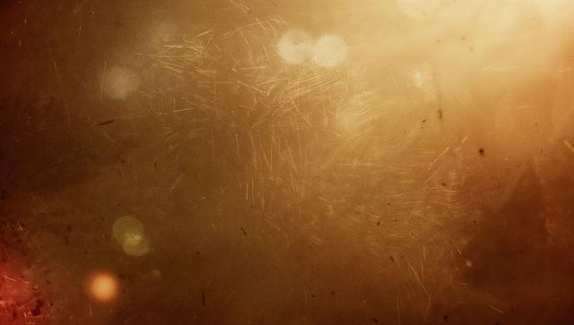 Abstract luminous scratched golden surface with circular light flares