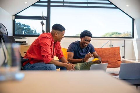 Diverse Colleagues Collaborating in Loft Office with Laptops