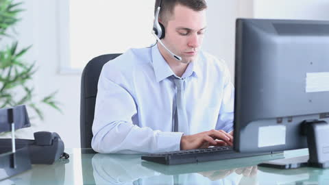Office Worker with Headset Attentive at Desk
