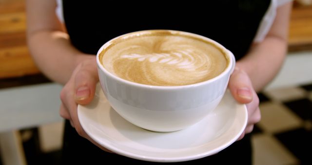 Mid section of waitress holding cup of coffee in cafe 4k