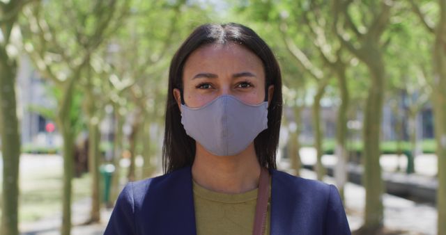 Confident businesswoman wearing face mask in park - Download Free Stock Images Pikwizard.com