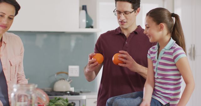 This image showcases a cheerful family spending quality time together in their modern kitchen. The scene reflects joy, love, and family bonding, making it ideal for campaigns focused on family lifestyle, home activities, cooking, healthy living, and household products. It can be used in advertisements, social media, and blogs related to family unity, parenting, cooking, and domestic life.