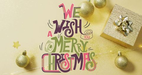 Hand-lettered merry christmas typography glowing with fairy lights and gold glitter