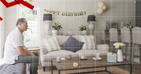 Man Sitting on Ottoman Holding Party Blower Celebrating Intimate Home Birthday with Cake