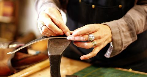 Craftswoman Skillfully Working with Leather in Artisanal Workshop