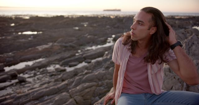 Young Man Contemplating on Rocky Shore at Sunset - Download Free Stock Images Pikwizard.com