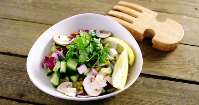 This vibrant vegetable salad features fresh mushrooms, cucumbers, red onions, corn, and lemons, garnished with cilantro. Ideal for promoting healthy eating, vegan recipes, and fresh meal inspiration. Great for food blogs, nutrition websites, and wellness marketing.