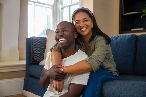 Happy Couple Embracing on Couch in Cozy Living Room