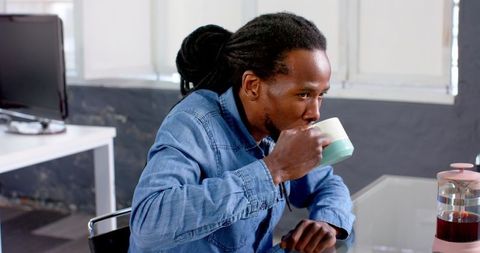 Man Enjoying Coffee Break in Relaxed Office Environment