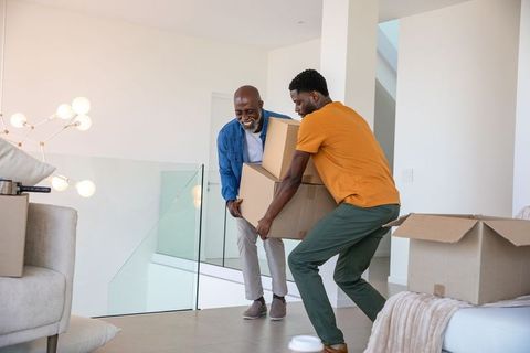 Father and Son Moving Boxes in Modern Home Living Room