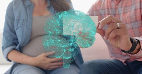 Pregnant couple viewing holographic brain projection technology with health card at home