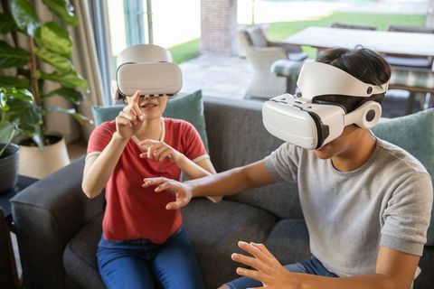 Asian Friends Engaging in Immersive Virtual Reality Experience at Home