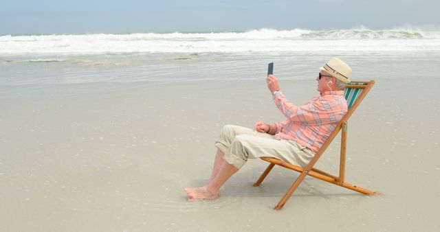 Senior Man Relaxing On Beach Chair While Taking Selfie At Seashore - Download Free Stock Images Pikwizard.com