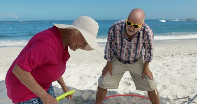 Senior Couple Enjoying Day at Beach with Sand Toys and Laughter - Download Free Stock Images Pikwizard.com