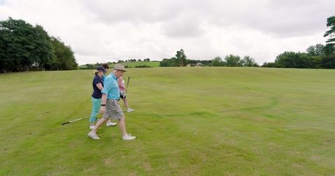 Group of Friends Strolling Along Golf Course on Cloudy Day