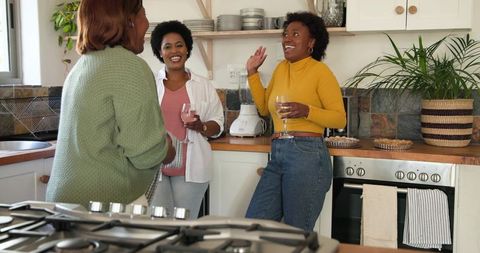 Friends Laughing and Enjoying Wine in Cozy Kitchen Gathering