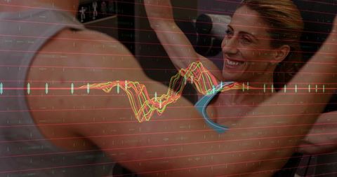 Smiling woman raising arms during partner-coached workout with fitness data overlay