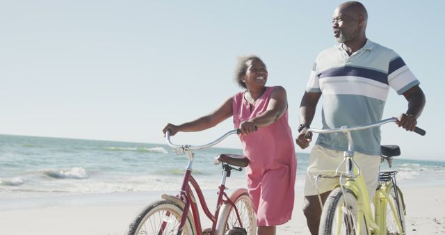 Senior couple enjoying a bike ride along the beach on a sunny day. They are smiling and appearing happy and healthy, embodying an active and joyful retirement. Perfect for highlighting themes of outdoor recreation, healthy living, togetherness, and leisure during retirement. Ideal for use in marketing materials for travel agencies, retirement planning services, health and wellness brands, and inspirational senior lifestyle content.