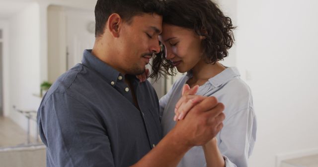 Image depicting loving couple gently embracing, sharing a tender moment at home. Idea for use in concepts related to love, relationships, romantic moments, togetherness, emotional connection, and affection in home settings.