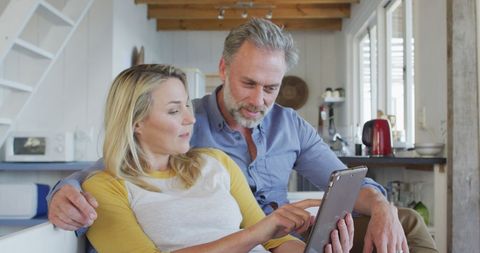Happy Middle-Aged Couple Relaxing and Using Tablet at Home - Download Free Stock Images Pikwizard.com