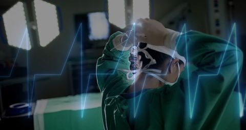 Surgeon Adjusting Cap in Operating Room with Heartbeat Overlay - Download Free Stock Images Pikwizard.com