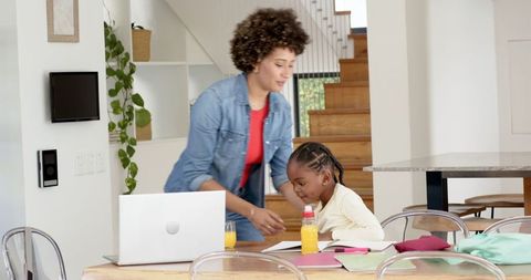 Mother and Daughter Collaborating on Homework in Modern Dining Area