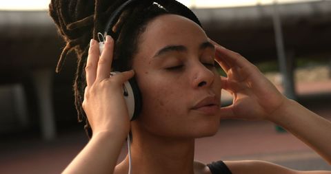 Peaceful Moment, Young Woman Immersed in Music with Headphones Outdoors