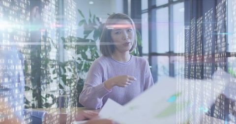 Diverse business professionals engaging in data analysis with digital overlay