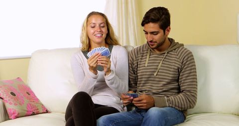 Happy Couple Enjoying Card Game on Couch at Home