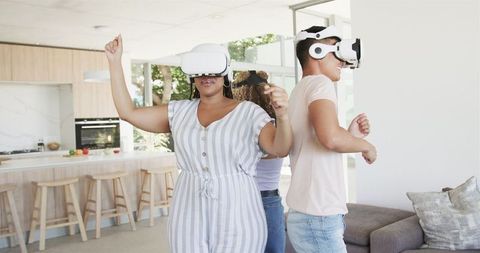 Bicultural Friends Enjoying VR Experience Indoors in Modern Kitchen