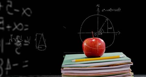 Apple and textbooks with math concepts on blackboard background