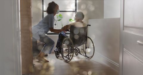 Healthcare Professional Assisting Patient in Wheelchair with Bokeh Effect - Download Free Stock Images Pikwizard.com