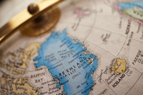 Vintage globe highlighting greenland and iceland under brass meridian close-up